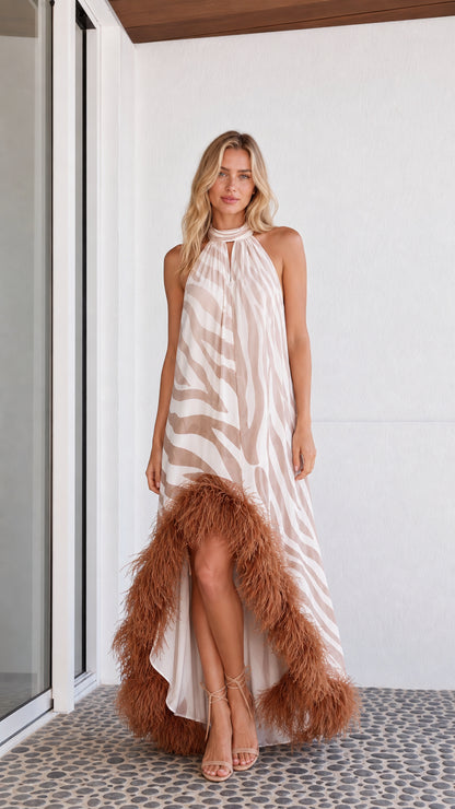 Front view of model wearing beige zebra print maxi dress with feather hem