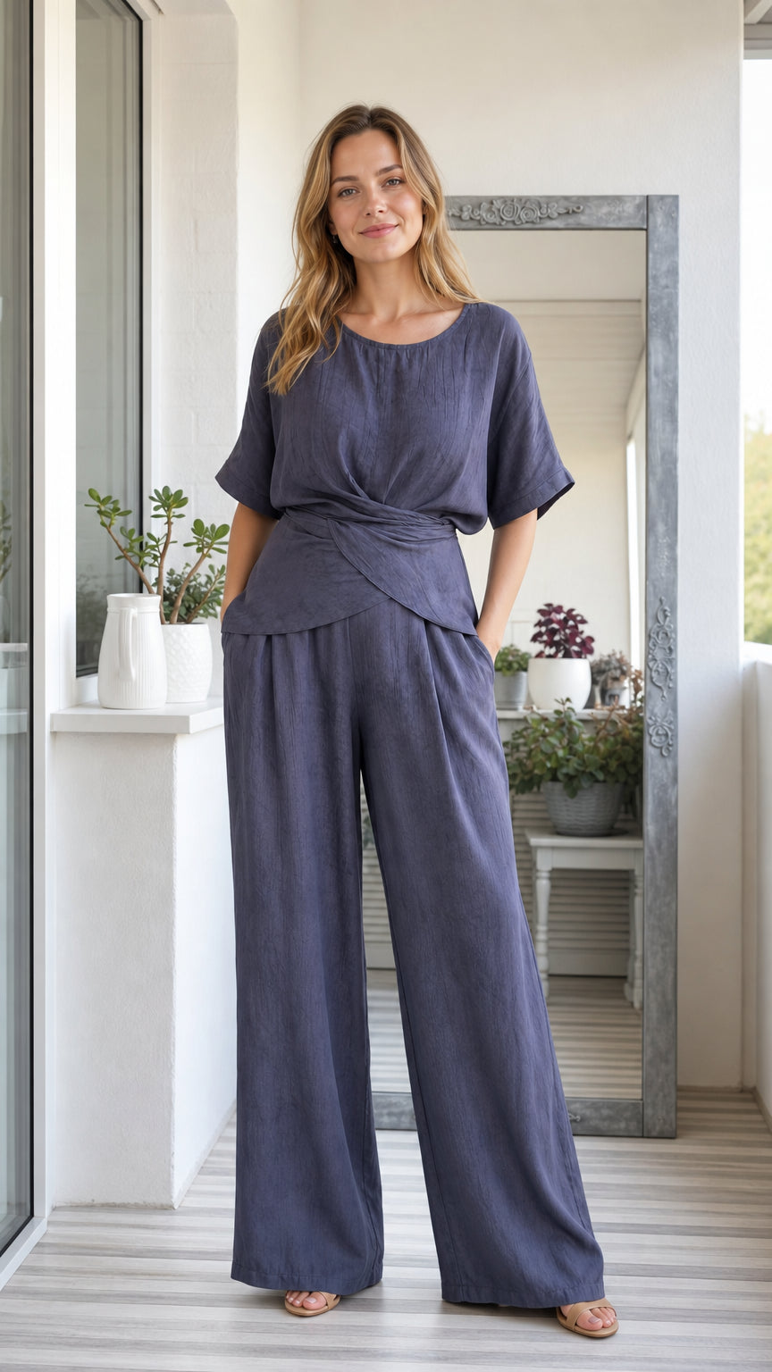 Front view of model wearing slate blue short sleeve twist top and matching wide leg pants set