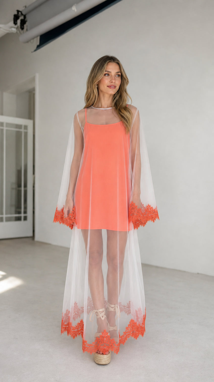 Model wearing coral two-piece sheer mesh duster and cami dress set, front view