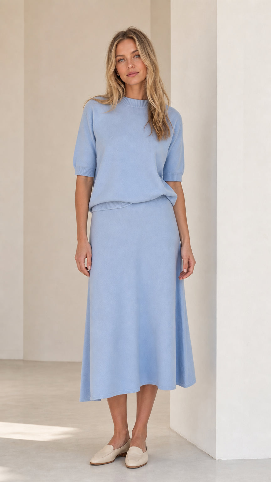Front view of woman wearing light blue knit top and matching midi skirt set