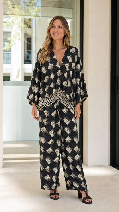 Woman wearing black geometric print two-piece set front view