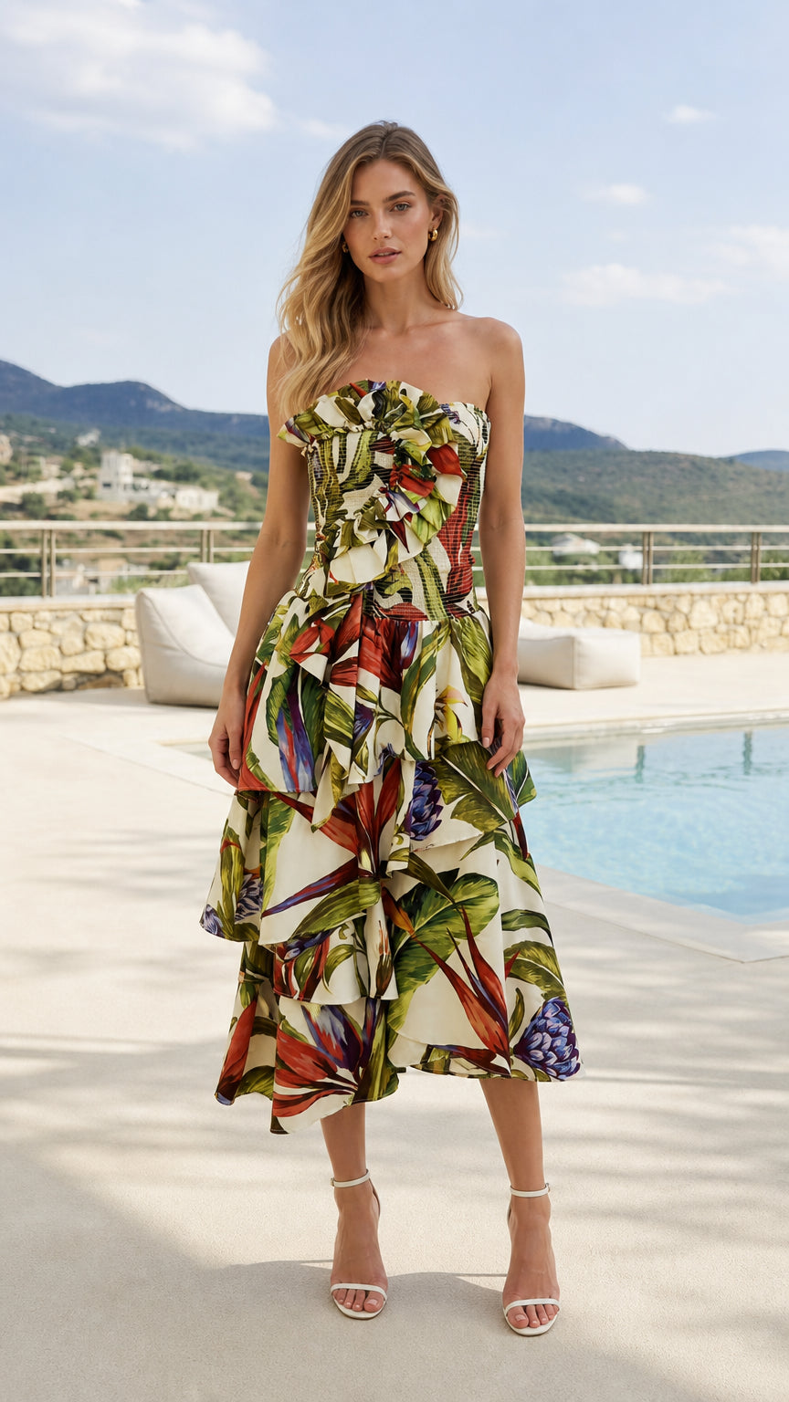 Front view of model wearing ivory tropical print strapless midi dress by a pool