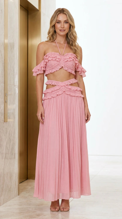 Front view of model wearing pink ruffle halter crop top and pleated maxi skirt set