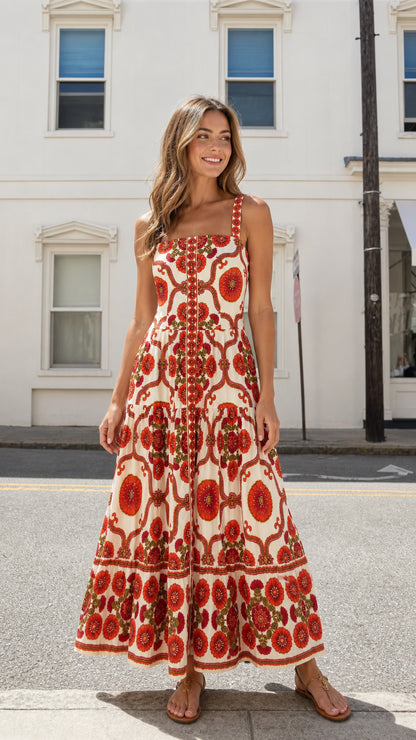 Front view of model wearing red floral square neck tiered maxi dress