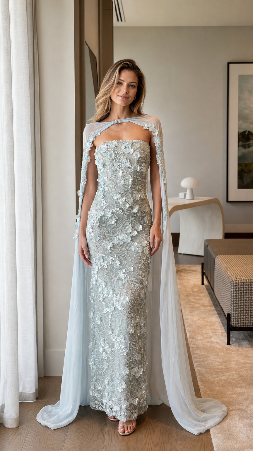 Front view of model wearing Ice Blue 3D floral applique strapless gown with sheer cape