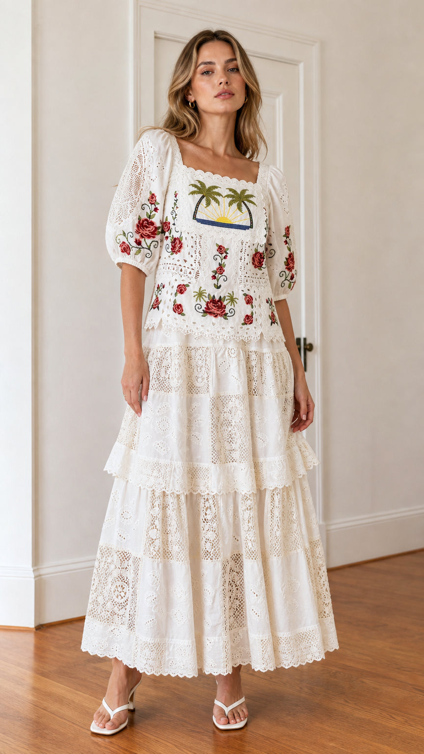 Front view of woman wearing white embroidered palm tree maxi dress