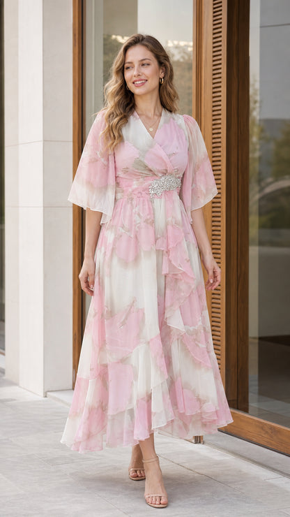 Front view of woman wearing blush pink floral chiffon midi dress with flutter sleeves