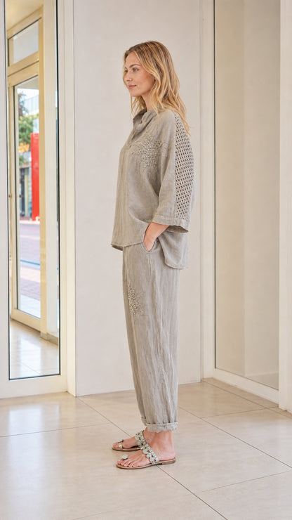 Side view of model wearing taupe two-piece set with sleeve detail