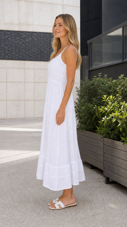 Woman wearing white smocked maxi dress, side profile