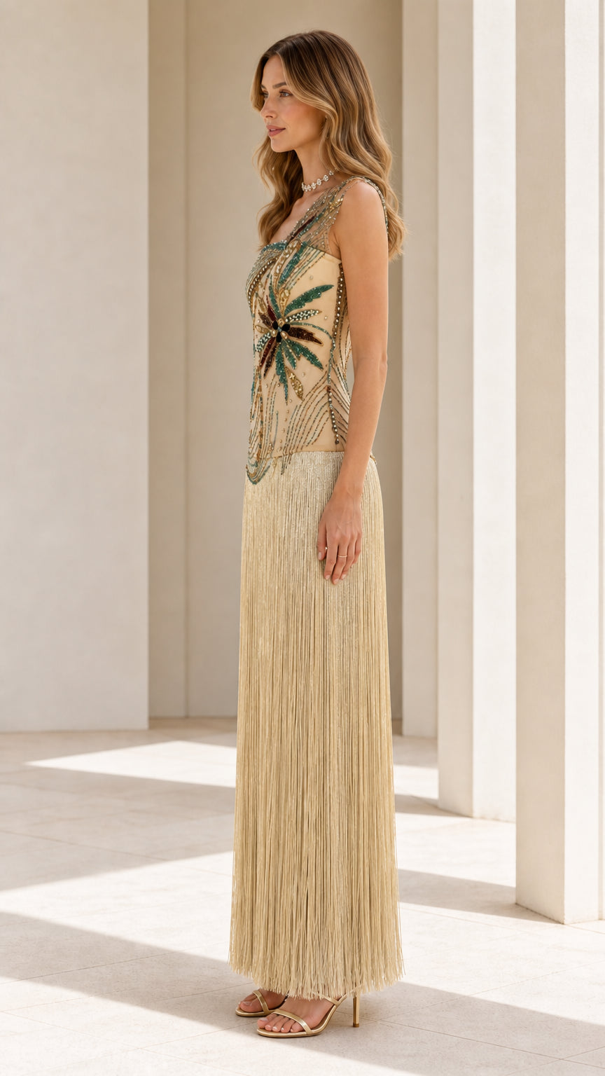 Side profile view of model in gold beaded fringe gown