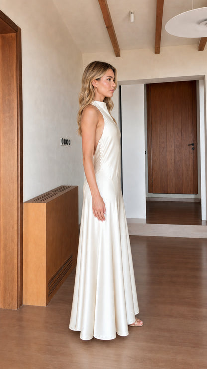 Side profile view of ivory satin halter maxi dress
