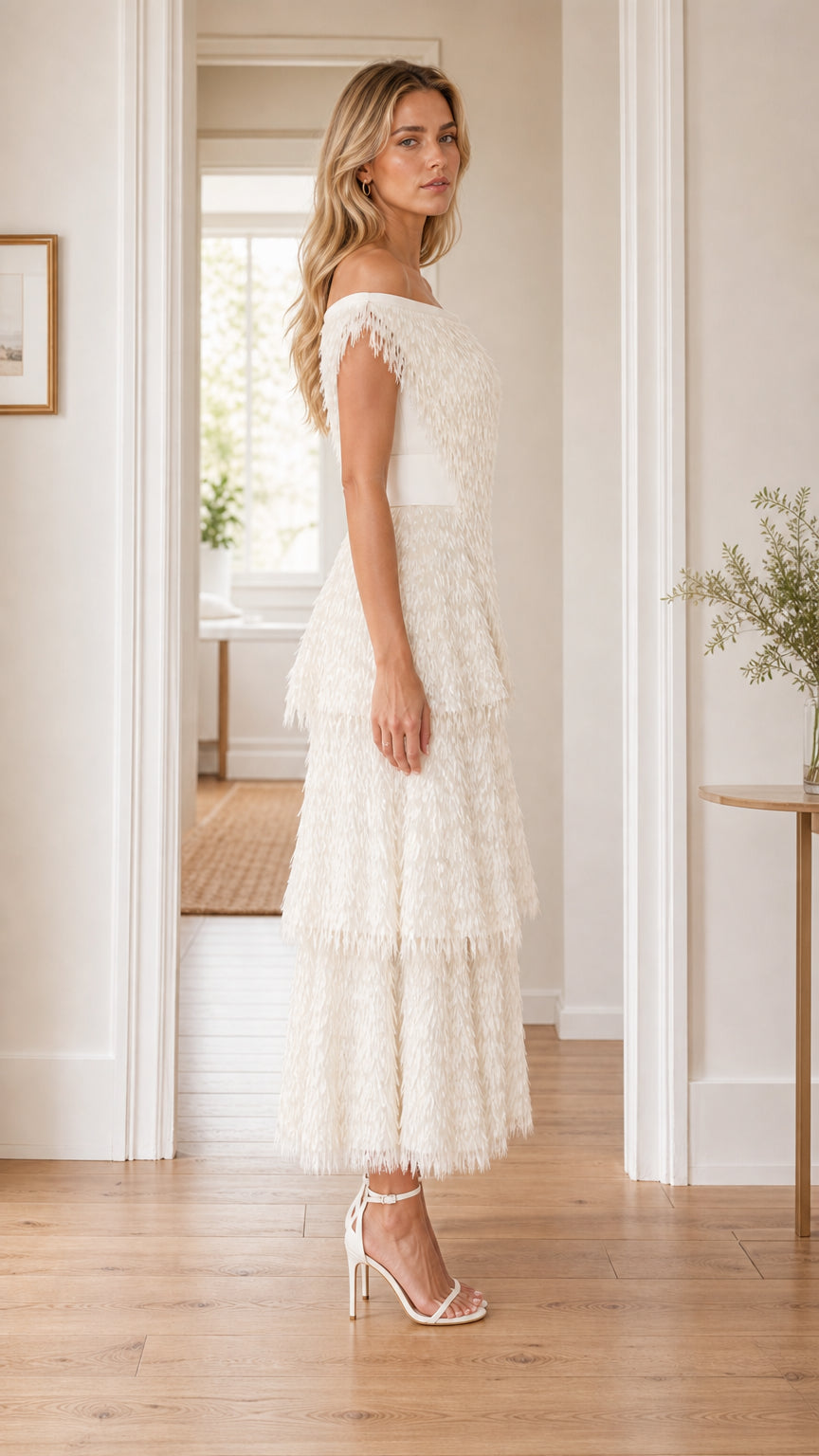 Side profile of woman in white fringe midi dress