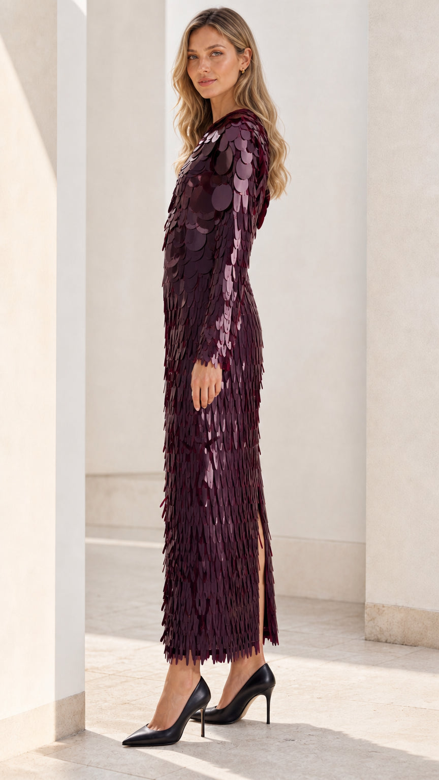 Side profile view of burgundy sequin dress with slit