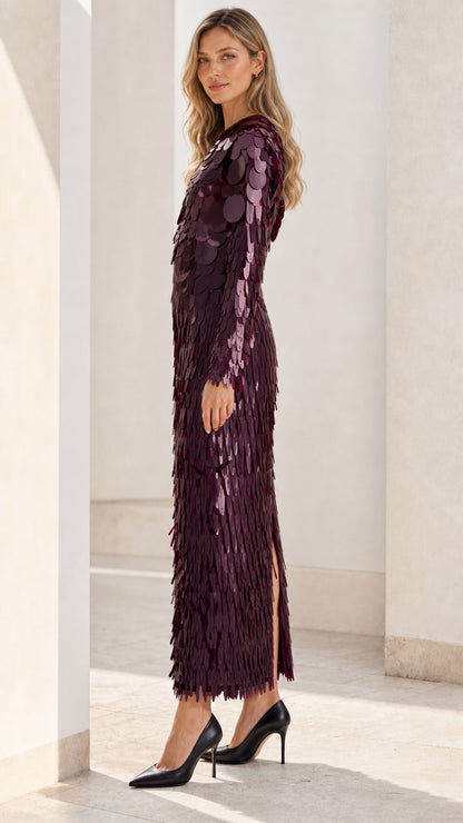Side profile view of burgundy sequin dress with slit