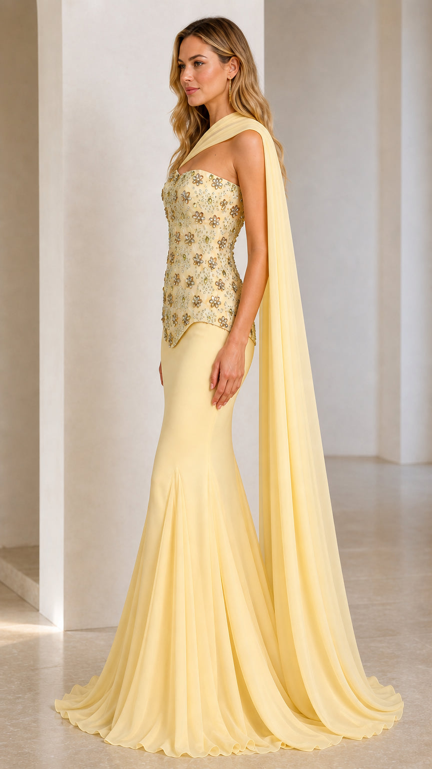 Side profile view of yellow evening dress with flowing cape drape