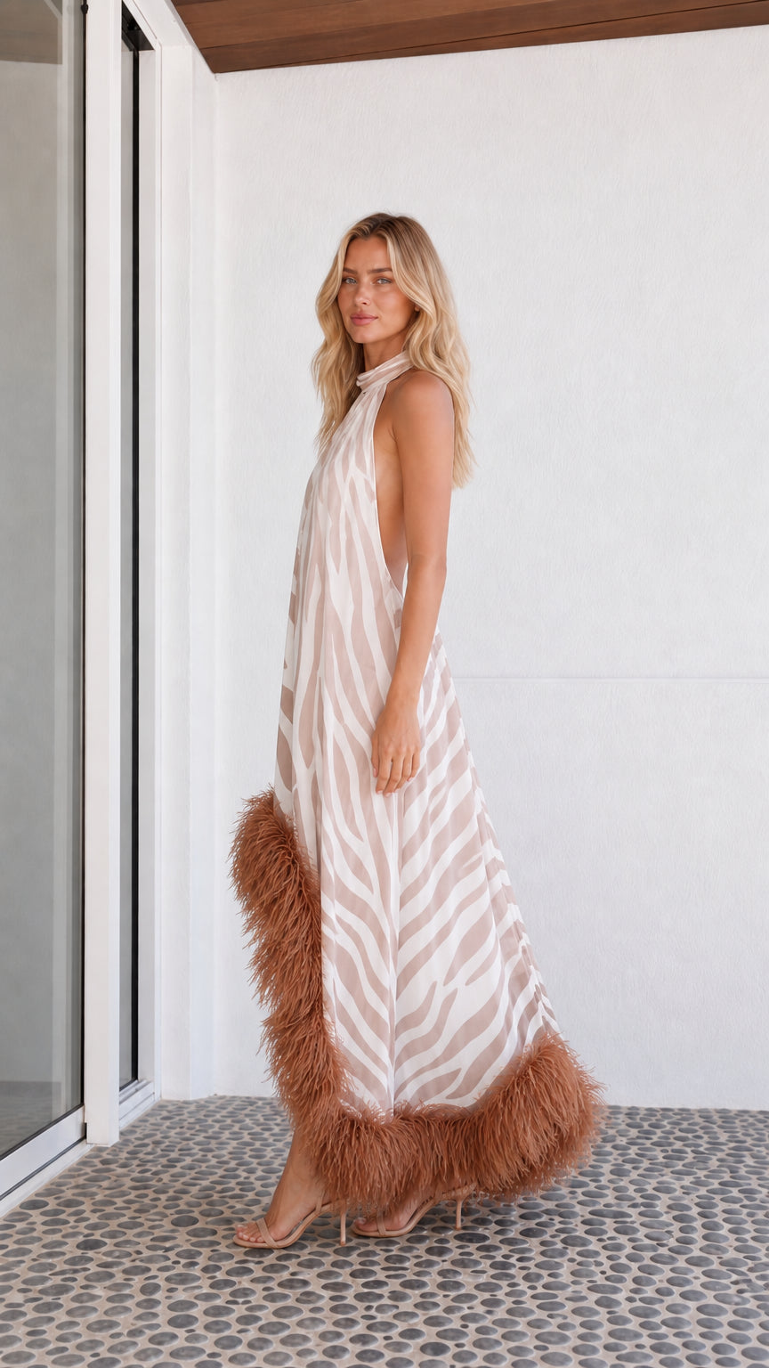 Side profile of model in beige zebra print dress