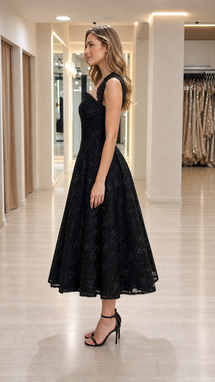 Side profile view of woman in black lace A-line dress