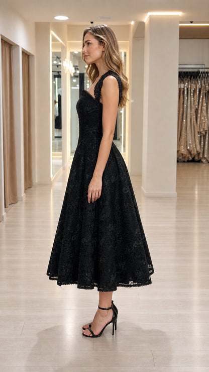 Side profile view of woman in black lace A-line dress