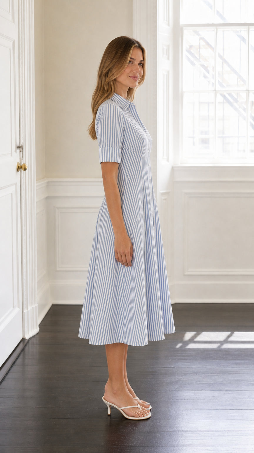Side profile of model wearing blue striped midi shirt dress