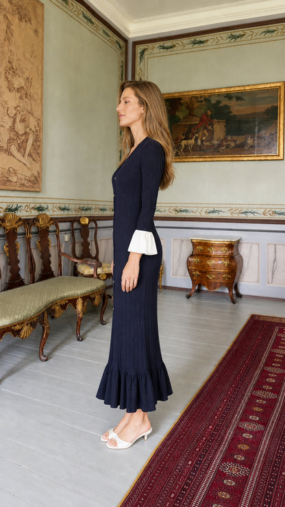 Side profile of model wearing navy blue knit midi dress