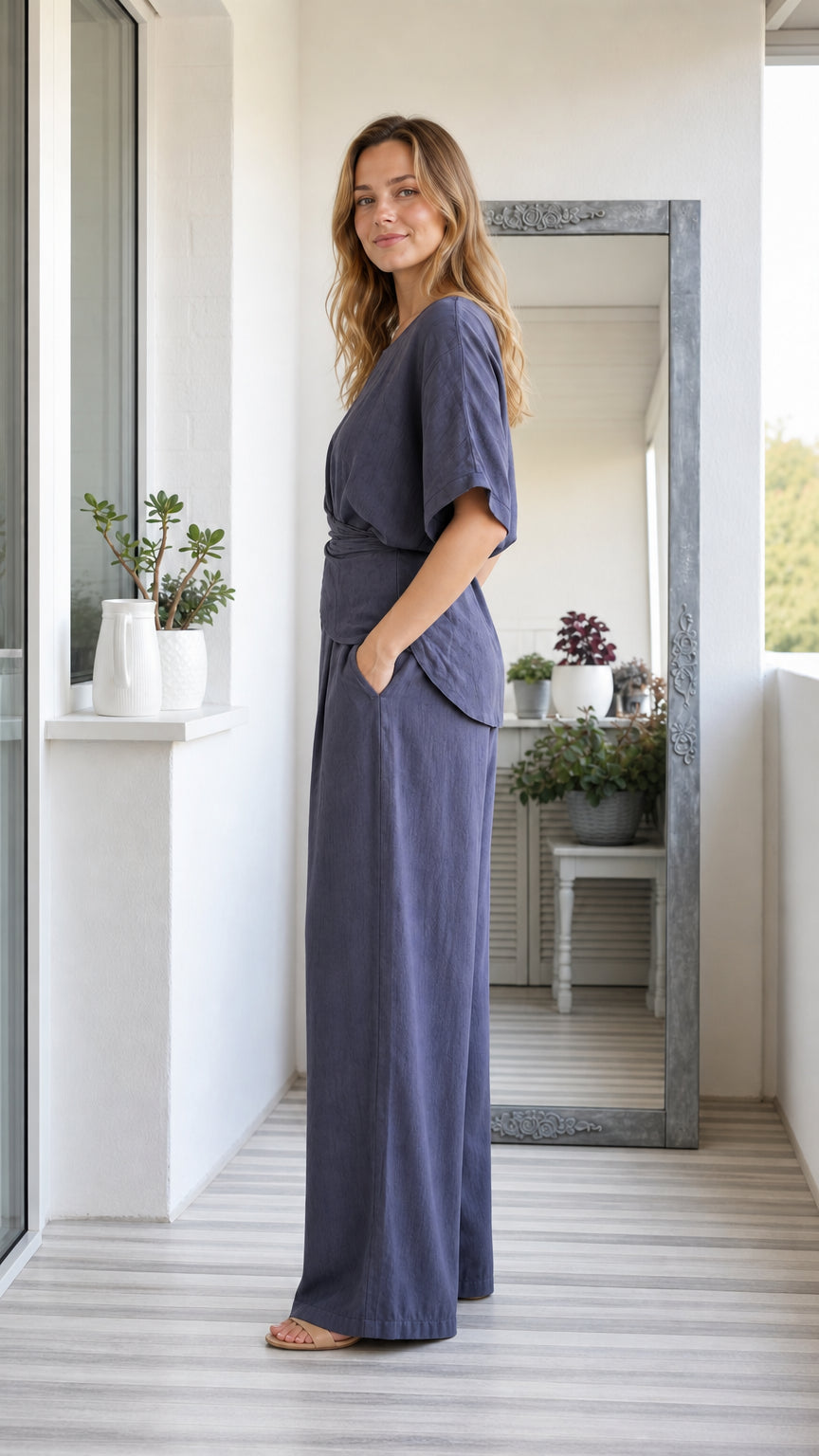 Side profile of model wearing slate blue two-piece linen-look pant set with pockets