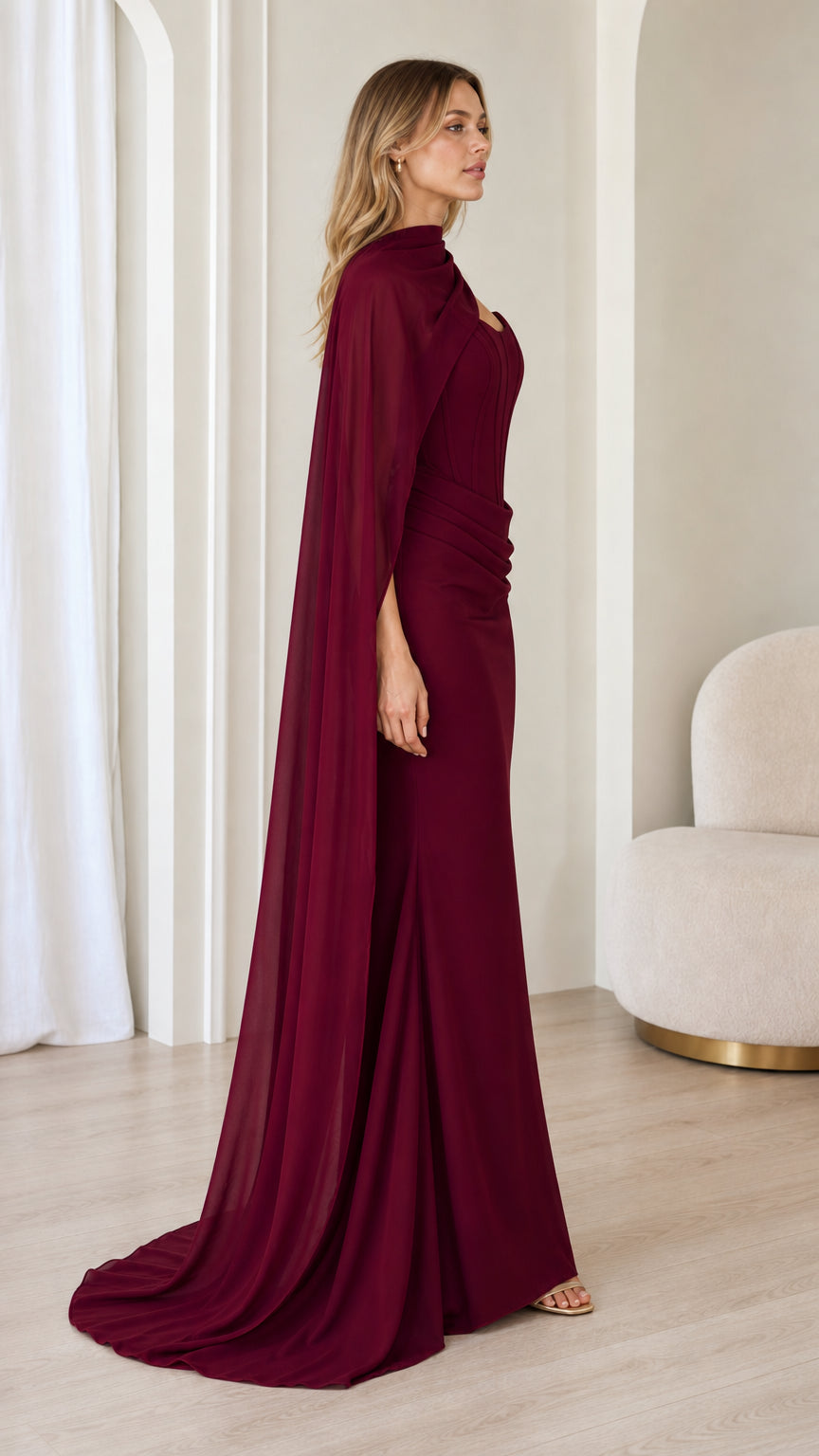 Side view of burgundy formal maxi gown with attached scarf cape