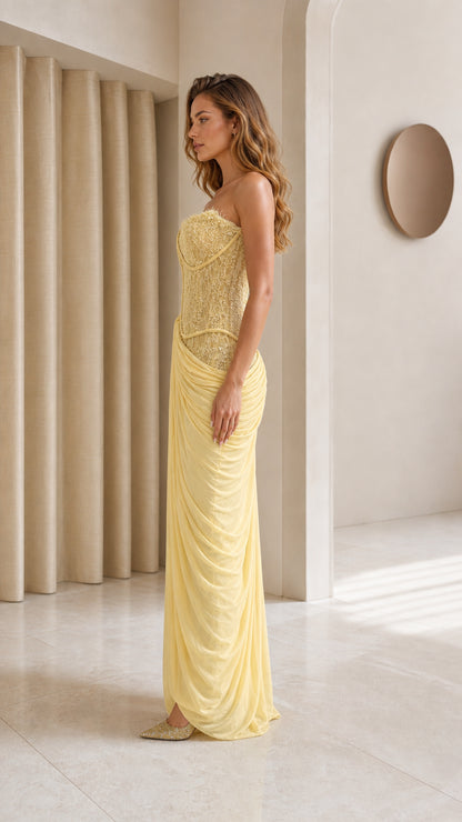 Model wearing yellow strapless evening gown side profile