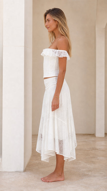 Side profile of woman in white off-shoulder corset and midi skirt set