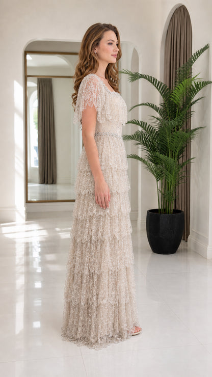 Side view of model wearing champagne tiered evening gown with flutter sleeves