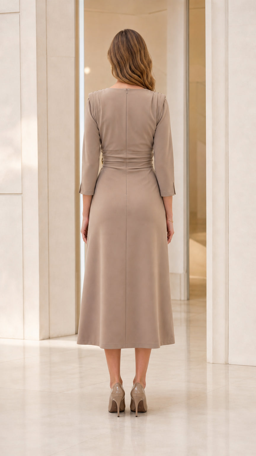 Back view of model in taupe midi dress highlighting clean seam lines