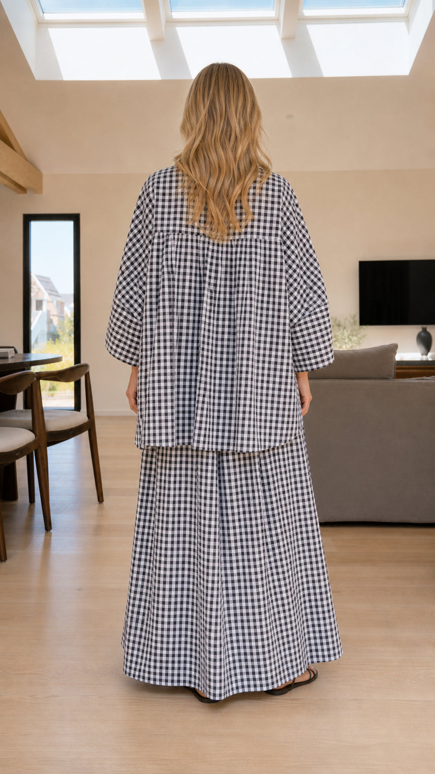 Back view of woman wearing black and white plaid shirt and pants