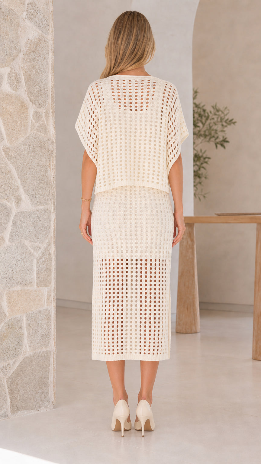 Model wearing off-white open-knit two piece skirt set, back view