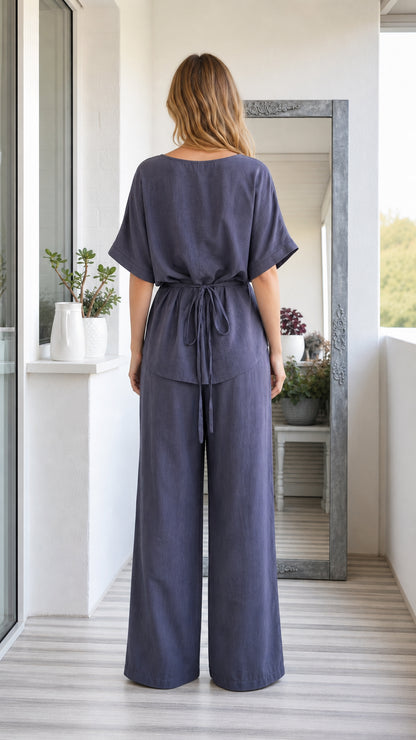 Back view of model wearing slate blue pant set showing the waist tie detail