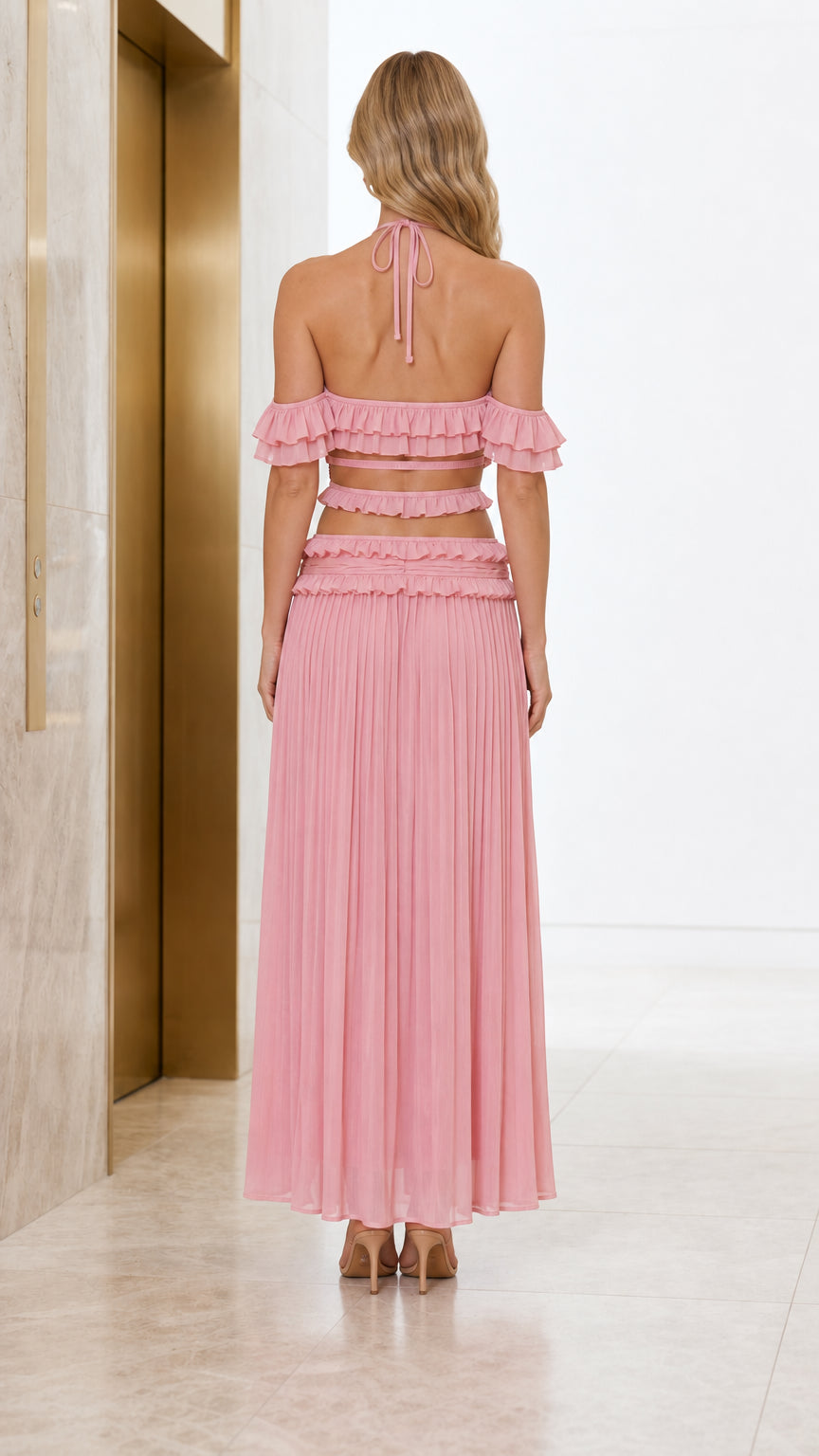 Back view of model showcasing halter tie and back details of pink set