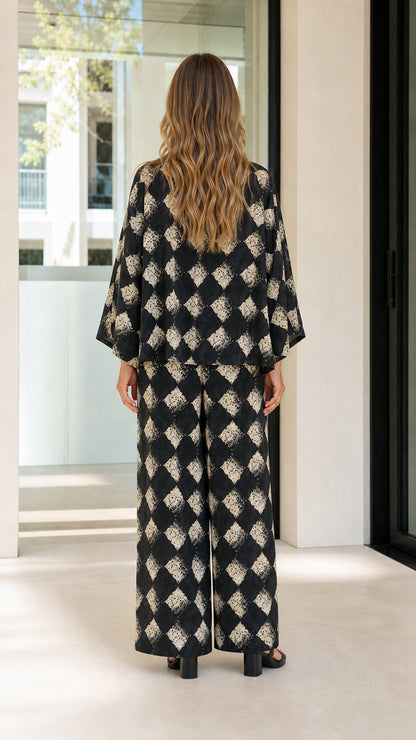 Woman wearing black geometric print two-piece set back view