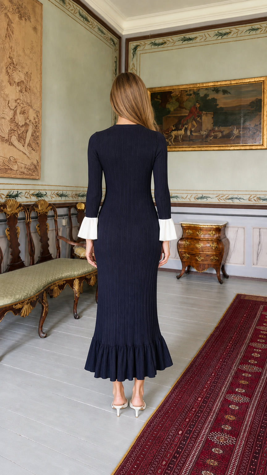 Back view of model wearing navy blue midi dress with flared hem