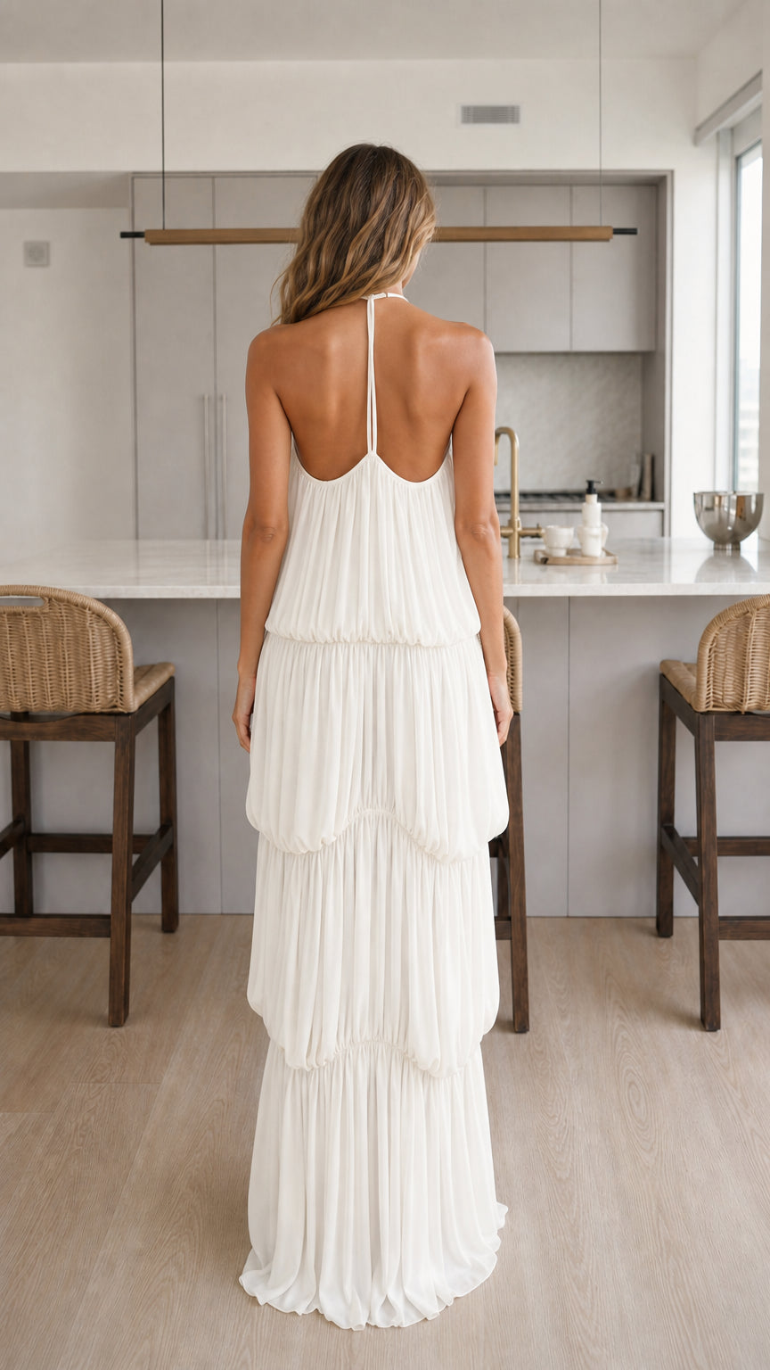 Back view of woman showing halter straps on white maxi dress