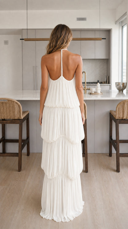 Back view of woman showing halter straps on white maxi dress