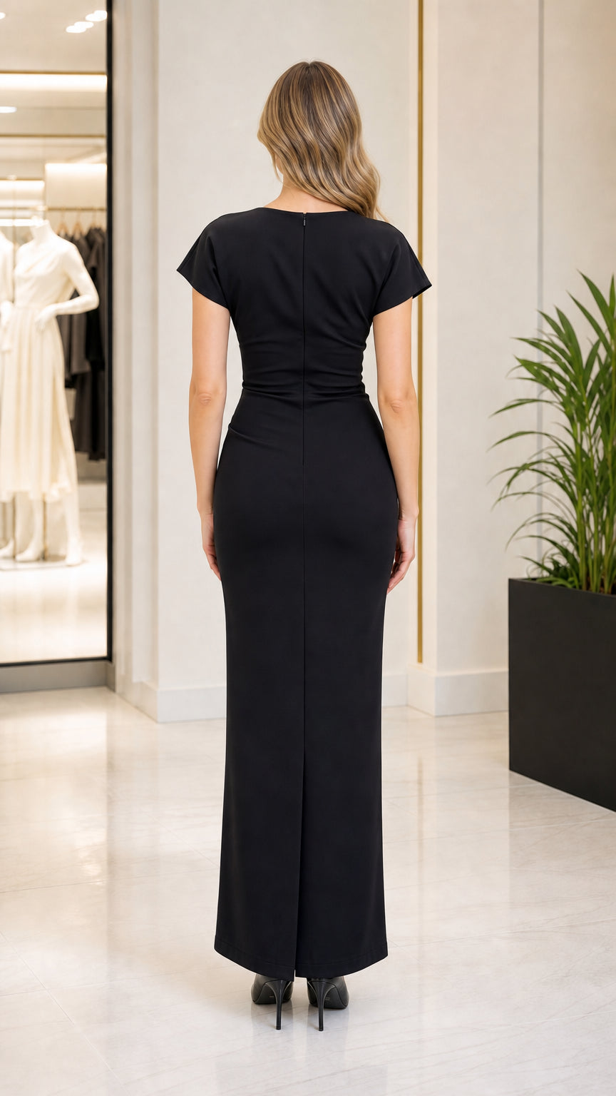 Back view of woman wearing black maxi dress showing subtle hem slit