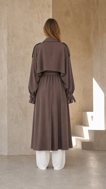 Back view of woman wearing dark taupe long trench coat