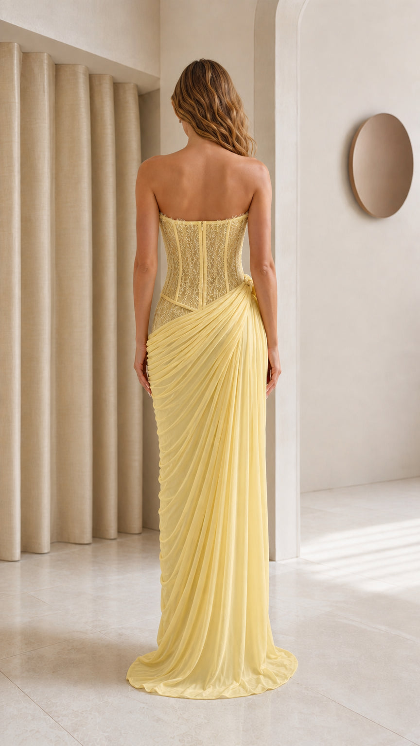 Model wearing yellow strapless evening gown back view