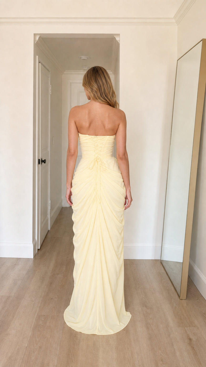 Back view of model in yellow strapless evening gown