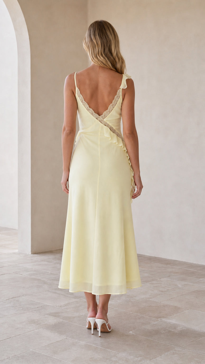 Model wearing yellow slip midi dress, back view
