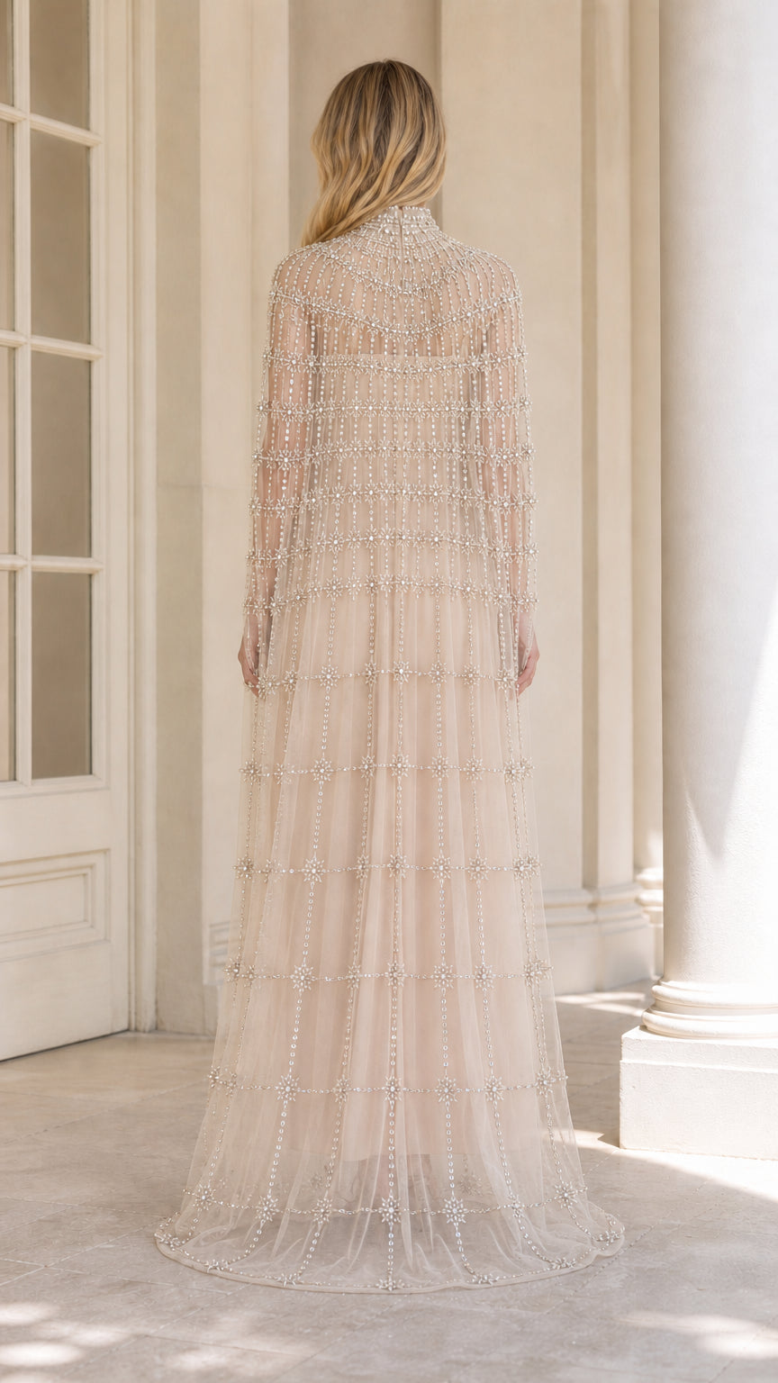 Back view of champagne floor-length embellished cape evening gown