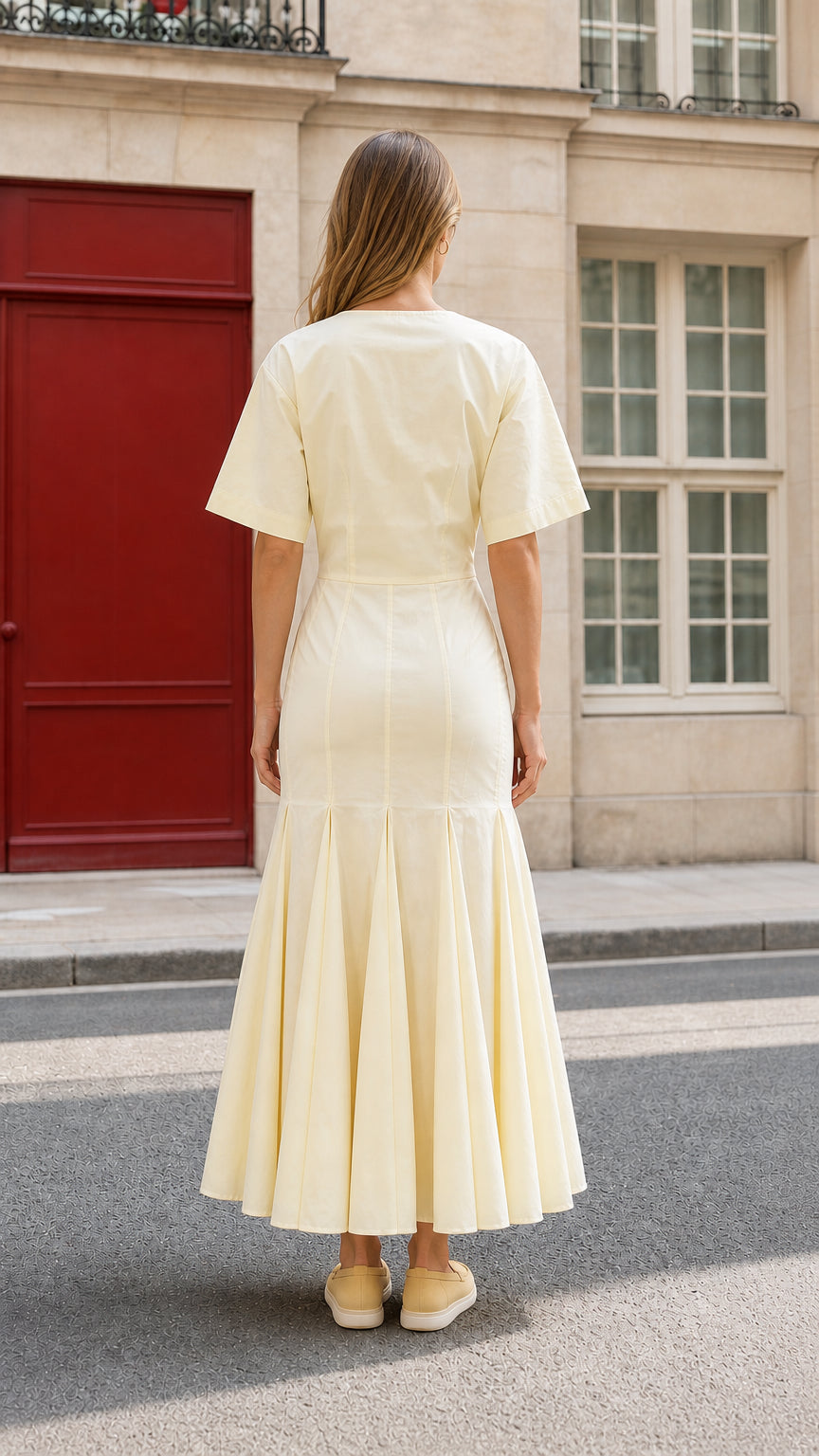Back view of woman wearing yellow midi dress showcasing structured silhouette