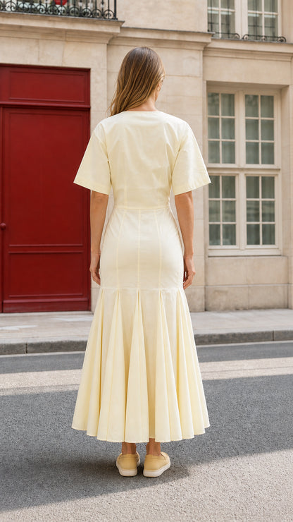 Back view of woman wearing yellow midi dress showcasing structured silhouette