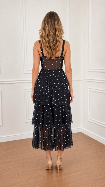 Model wearing Black polka dot tiered midi dress back view