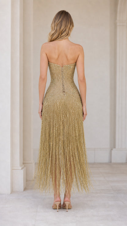 Back view of model showcasing lace-up corset detail on the gold fringe gown