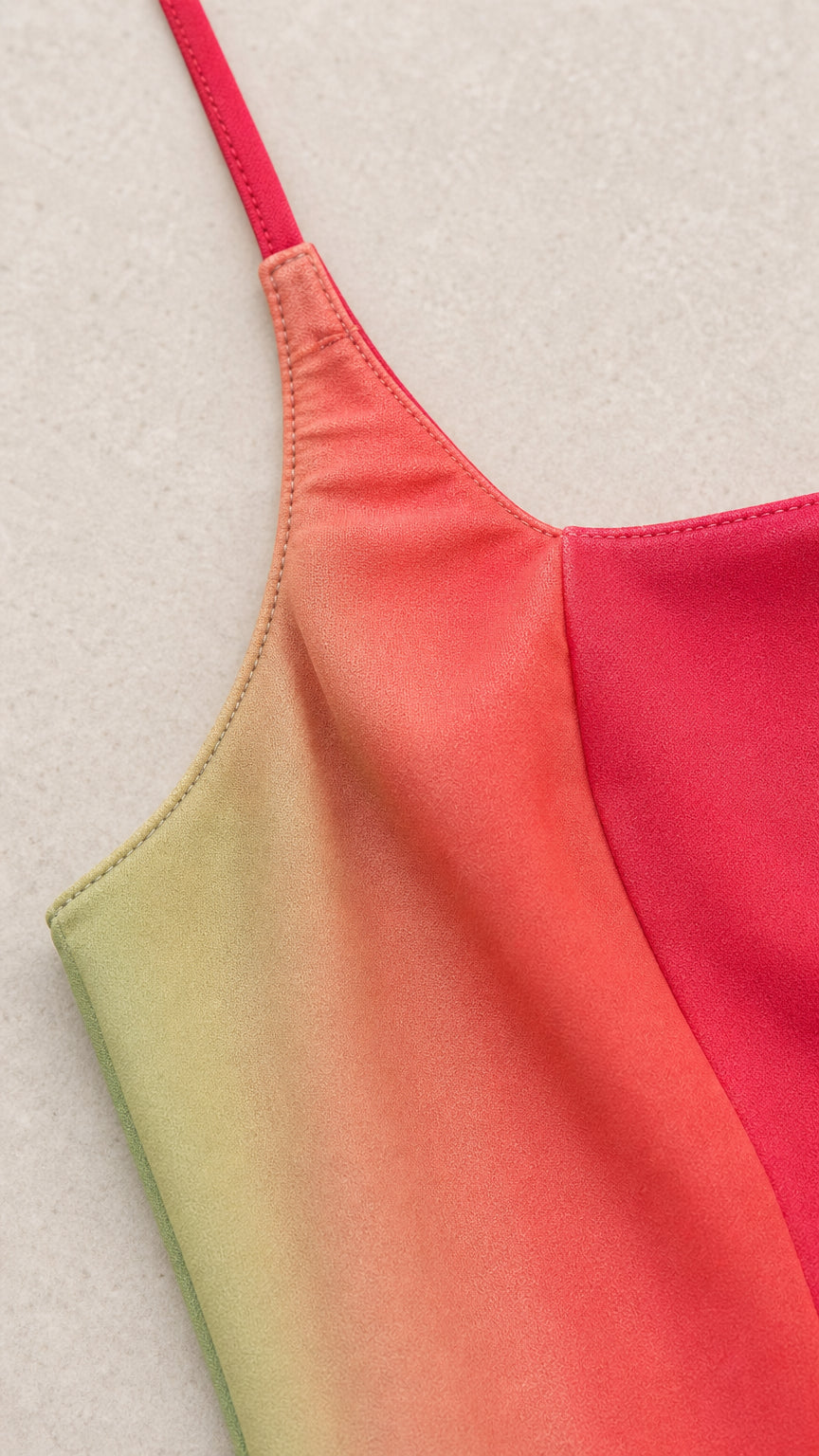 Close-up detail of spaghetti strap and red-to-green ombre fabric