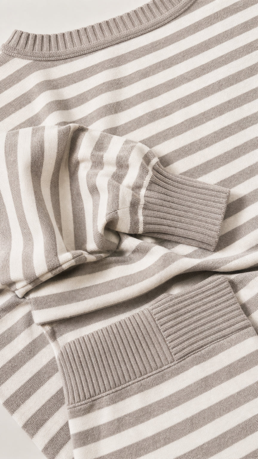 Close up of knit texture and ribbed cuffs on beige striped set